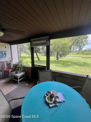 a living room with furniture potted plant and a large window