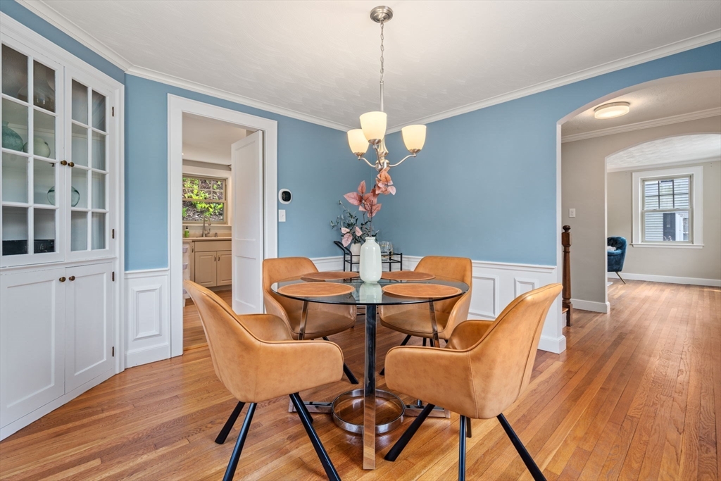 31 Northbourne Road Boston, MA 02130 - Photo 11 of 34 a dining room with wooden floor a chandelier a glass table and chairs