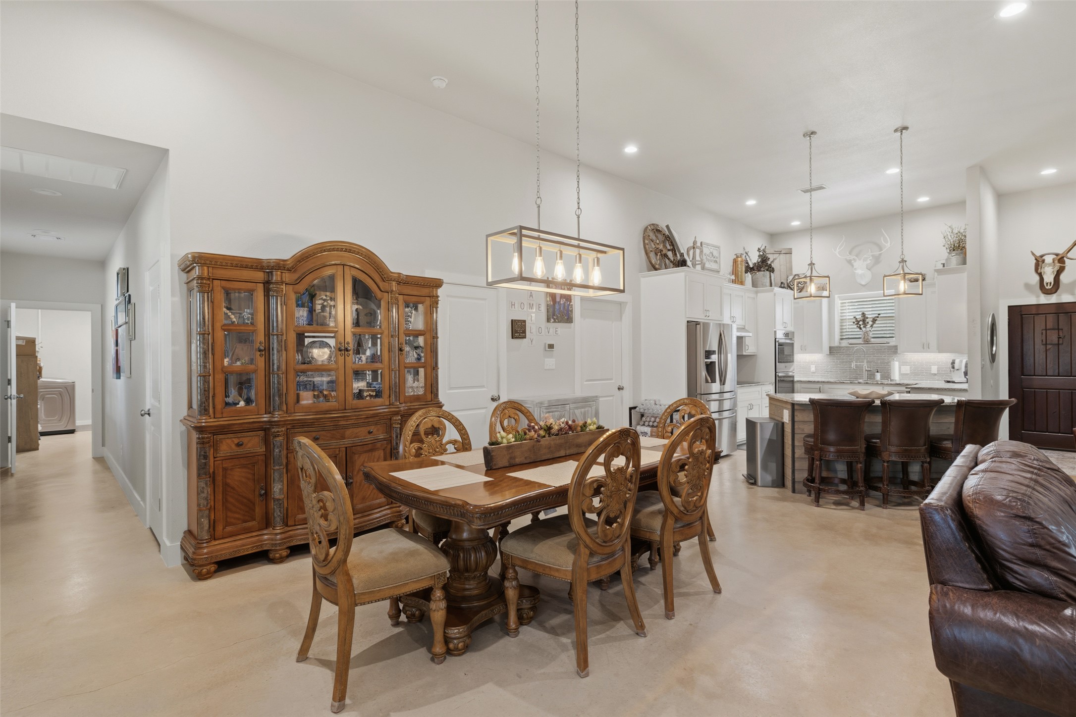 764 Stubbs Road Johnson City, TX 78636 - Photo 17 of 29 An open-concept living space integrates a well-appointed kitchen with a dining area, featuring an elegant chandelier.