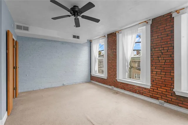 a view of an empty room with a window and a ceiling fan