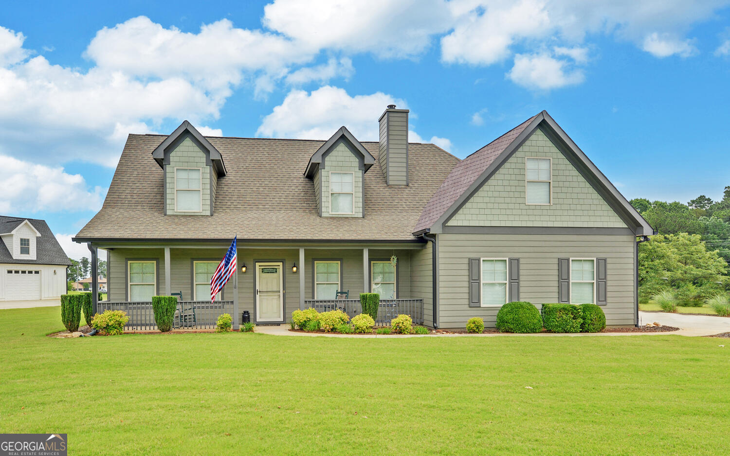 a front view of a house with swimming pool having outdoor seating