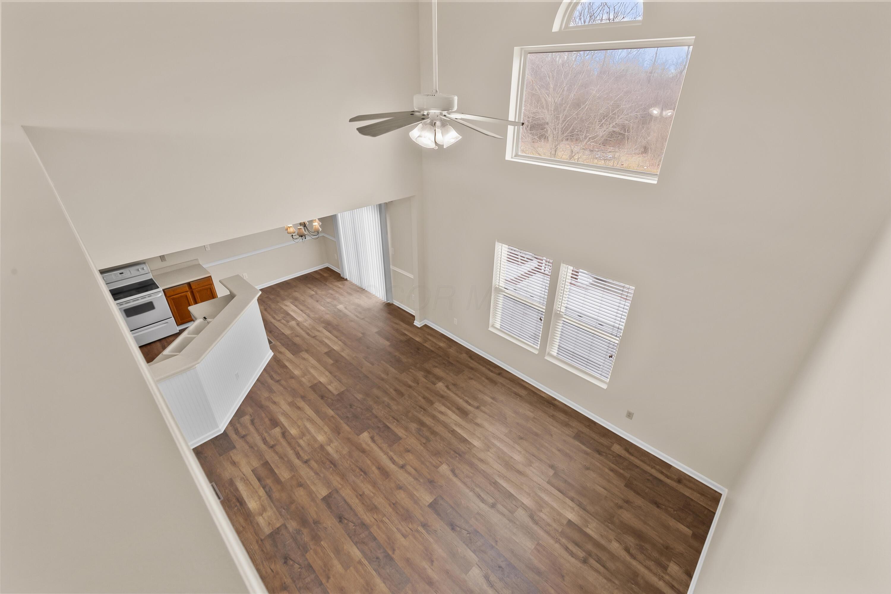 30 Tabilore Loop Delaware, OH 43015 - Photo 10 of 55 • New luxury vinyl plank flooring ~ 2025 • Tan painted walls • Two-story ceiling • Rectangular & half round window • Lighted ceiling fan