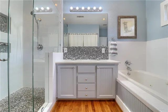 a bathroom with a tub shower and sink