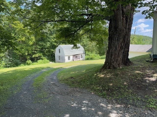 604 Main Road Granville, MA 01034 - Photo 23 of 36 a view of a tiny house with yard and large trees