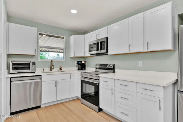 a kitchen with white cabinets stainless steel appliances and sink