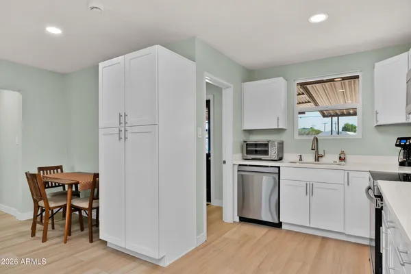 a kitchen with stainless steel appliances a stove a sink refrigerator and a chair