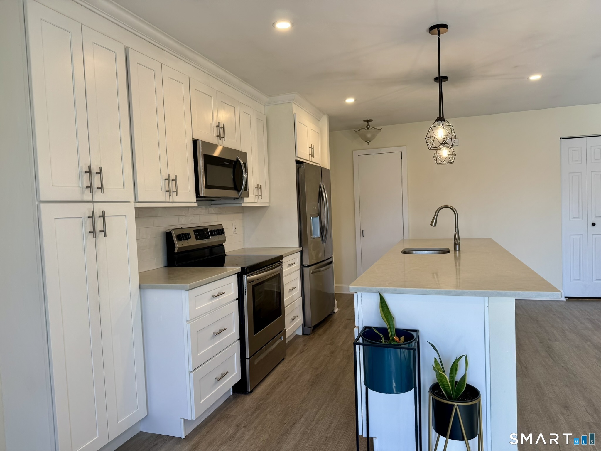 76 Maple Tree Avenue, Unit 6 Stamford, CT 06906 - Photo 5 of 27 a kitchen with kitchen island white cabinets and stainless steel appliances