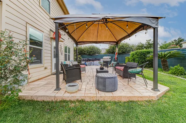 a view of backyard of house with outdoor seating and green space