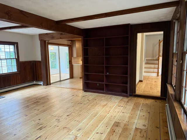 a view of empty room with wooden floor and windows