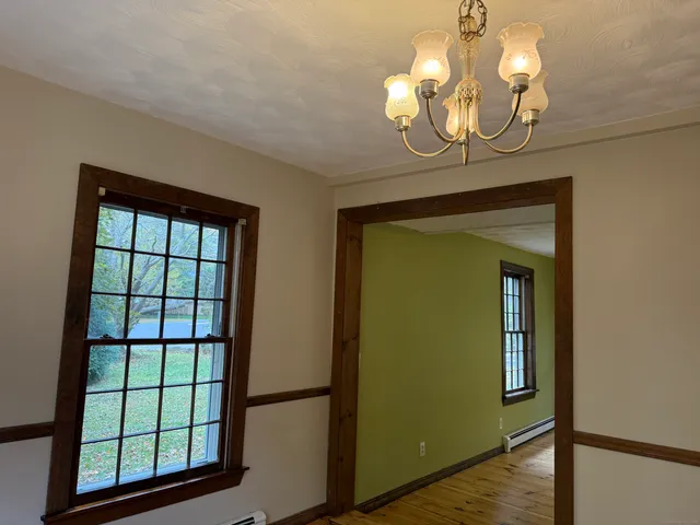 a view of a livingroom with a large window and wooden floor