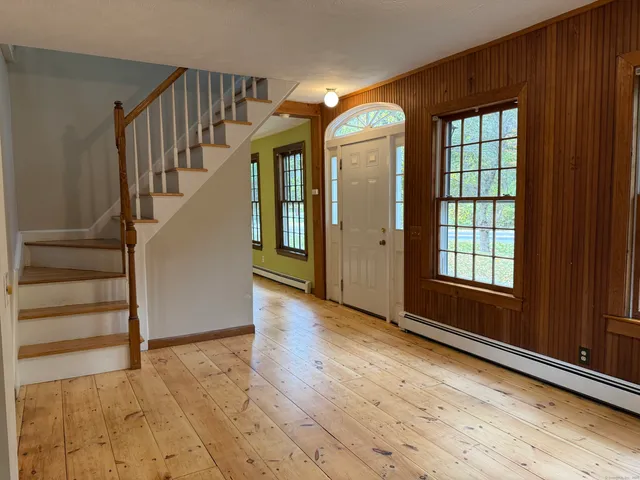 a view of empty room with stairs and wooden floor
