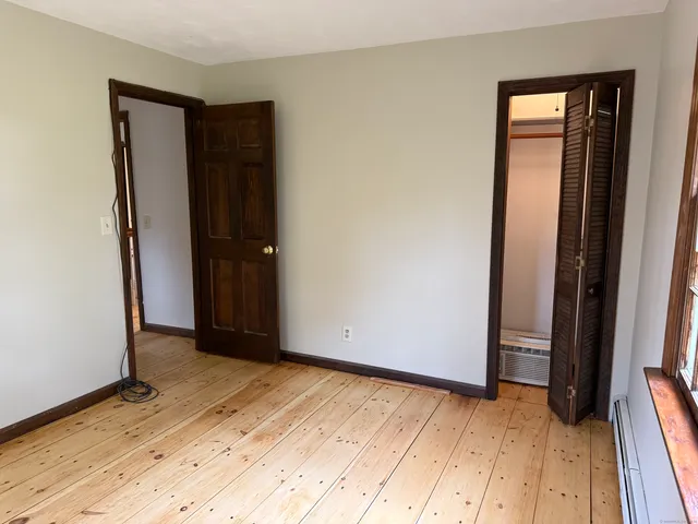 an empty room with wooden floor and closet