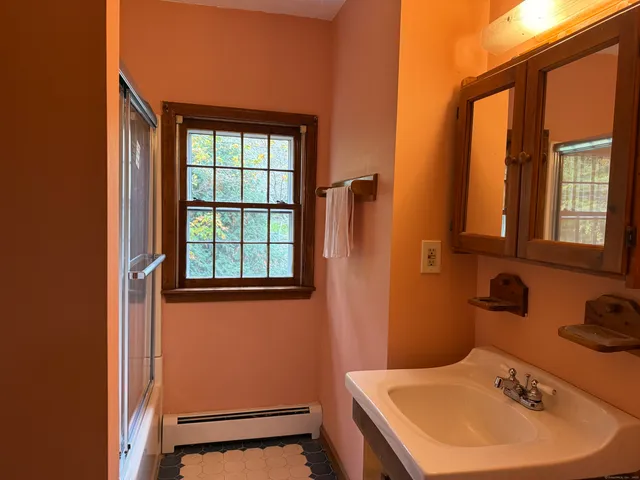 a bathroom with a sink a toilet and a mirror