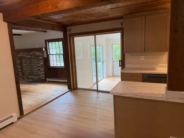 a view of an empty room with a window and wooden floor