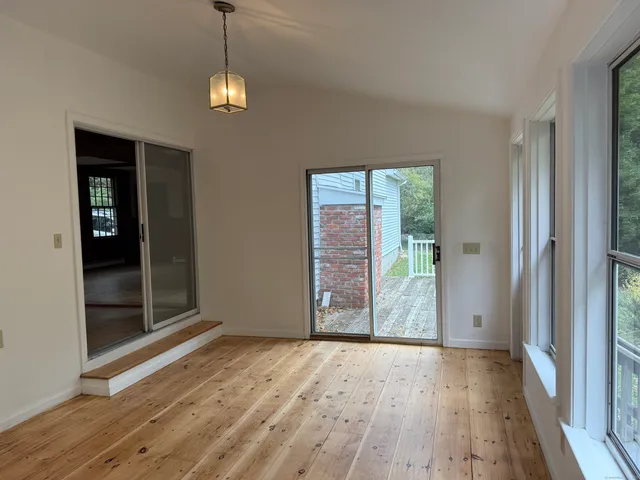 a view of a room with wooden floor and window