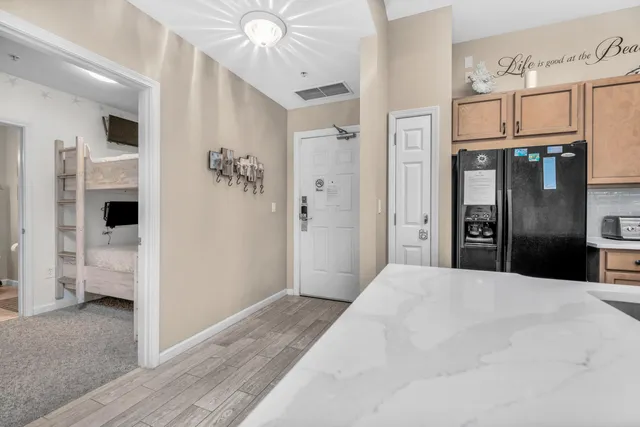 a large white kitchen with granite countertop a refrigerator and stove