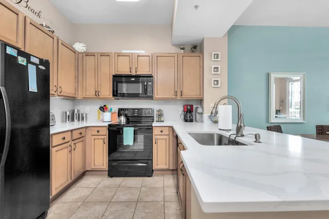 a kitchen with stainless steel appliances granite countertop a sink and refrigerator