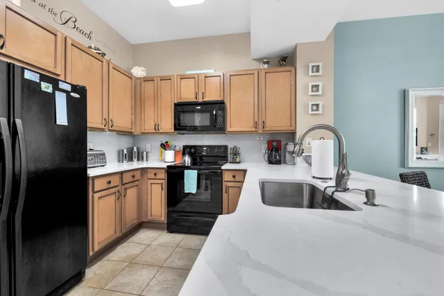 a kitchen with stainless steel appliances granite countertop a refrigerator sink and stove