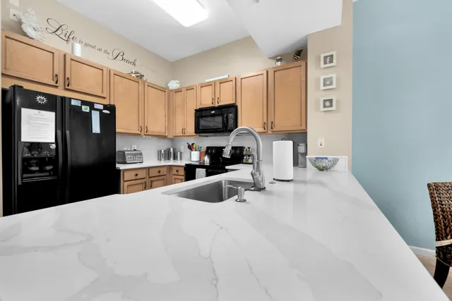 a kitchen with stainless steel appliances a refrigerator sink stove and microwave