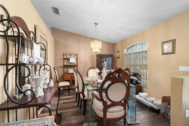 a living room with furniture a dining table and chairs with wooden floor