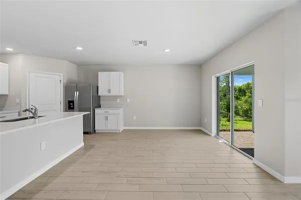 a large white kitchen with a sink a stove and a refrigerator