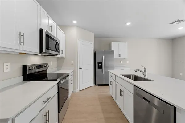 a kitchen that has a sink and a stove top oven