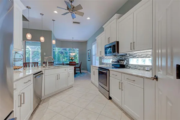 a kitchen with kitchen island granite countertop stainless steel appliances sink cabinets and a window
