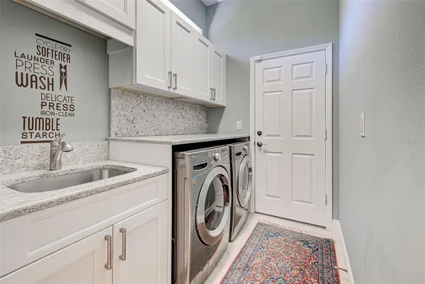 a utility room with sink dryer and washer