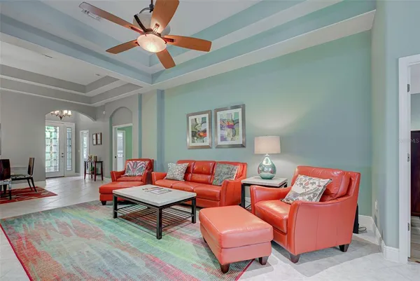 a living room with furniture a rug and a ceiling fan