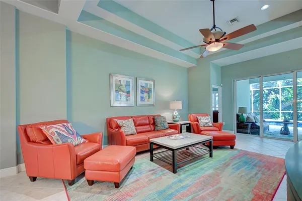 a living room with furniture a ceiling fan and a rug