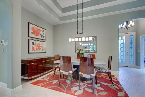 a dining room with furniture a chandelier and wooden floor