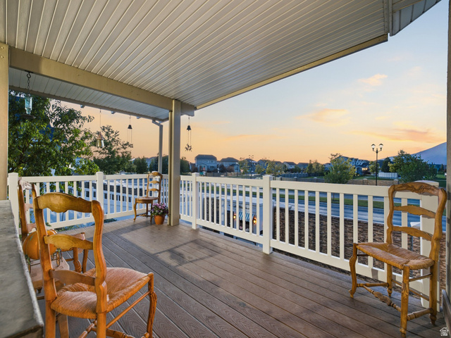 7 Sterling Loop Vineyard, UT 84059 - Photo 5 of 43 Covered porch featuring wood-finish decking, white railings, and a slatted ceiling with hanging fixtures