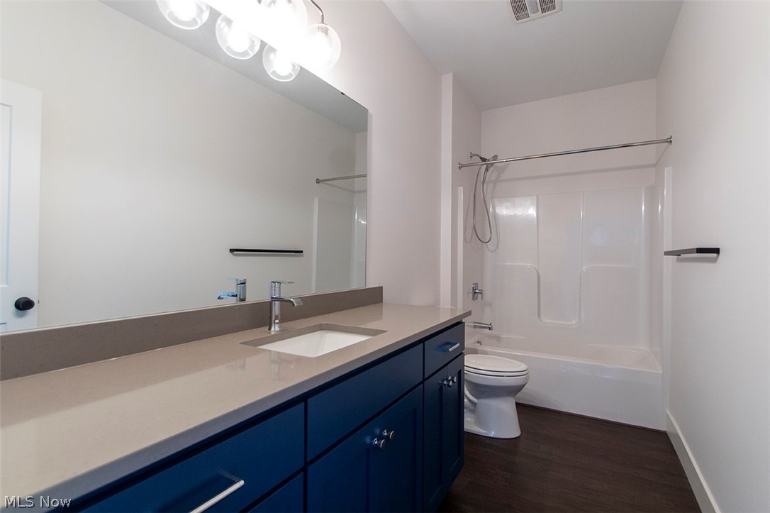 4197 Beach Road Medina, OH 44256 - Photo 27 of 35 Full bathroom with hardwood / wood-style flooring, toilet, bathtub / shower combination, and vanity