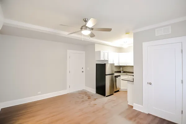 a view of a kitchen with a sink refrigerator and wooden floor