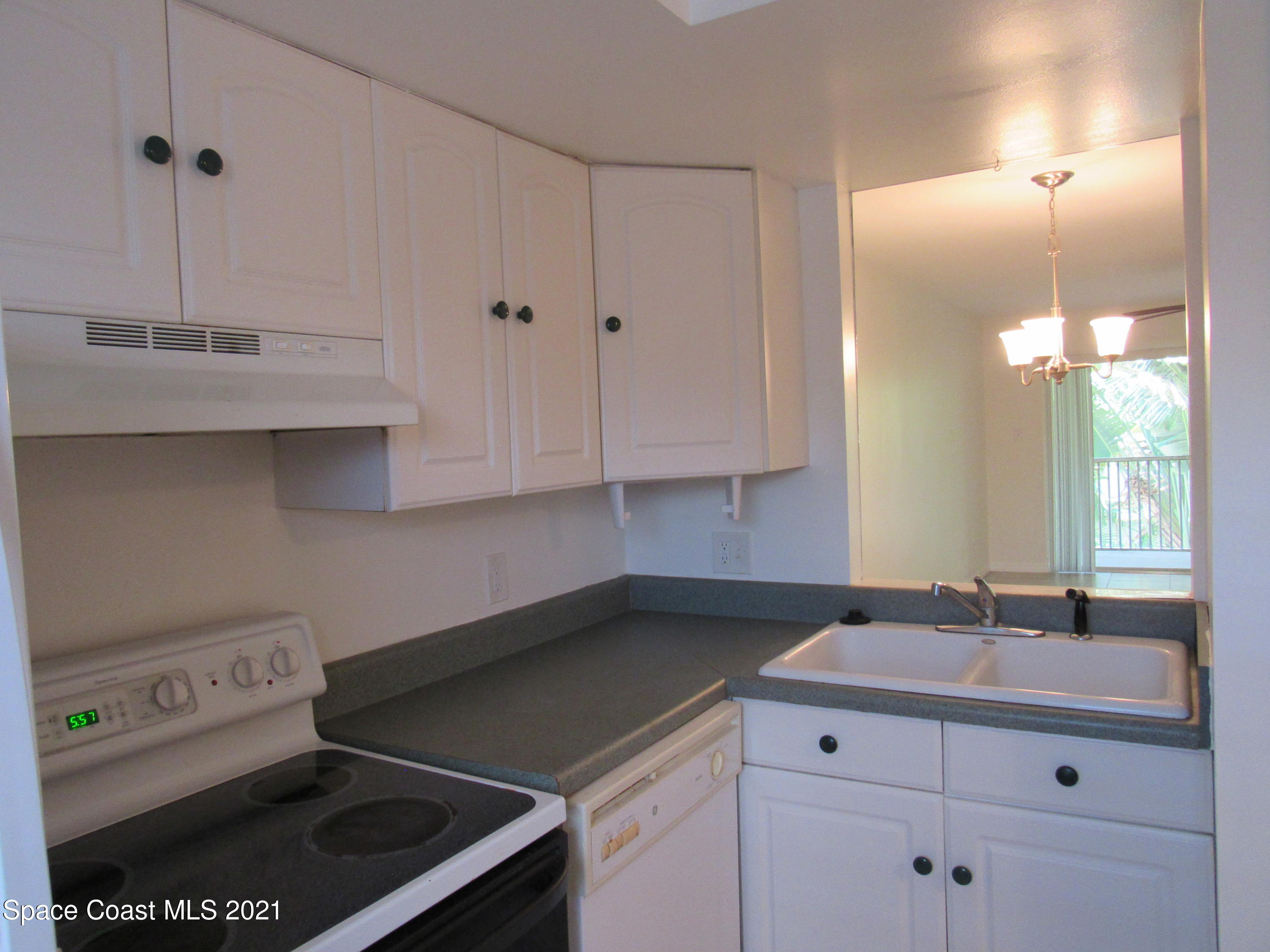 400 Catalina Road, Unit 203 Cocoa Beach, FL 32931 - Photo 3 of 10 a kitchen with a sink cabinets and appliances
