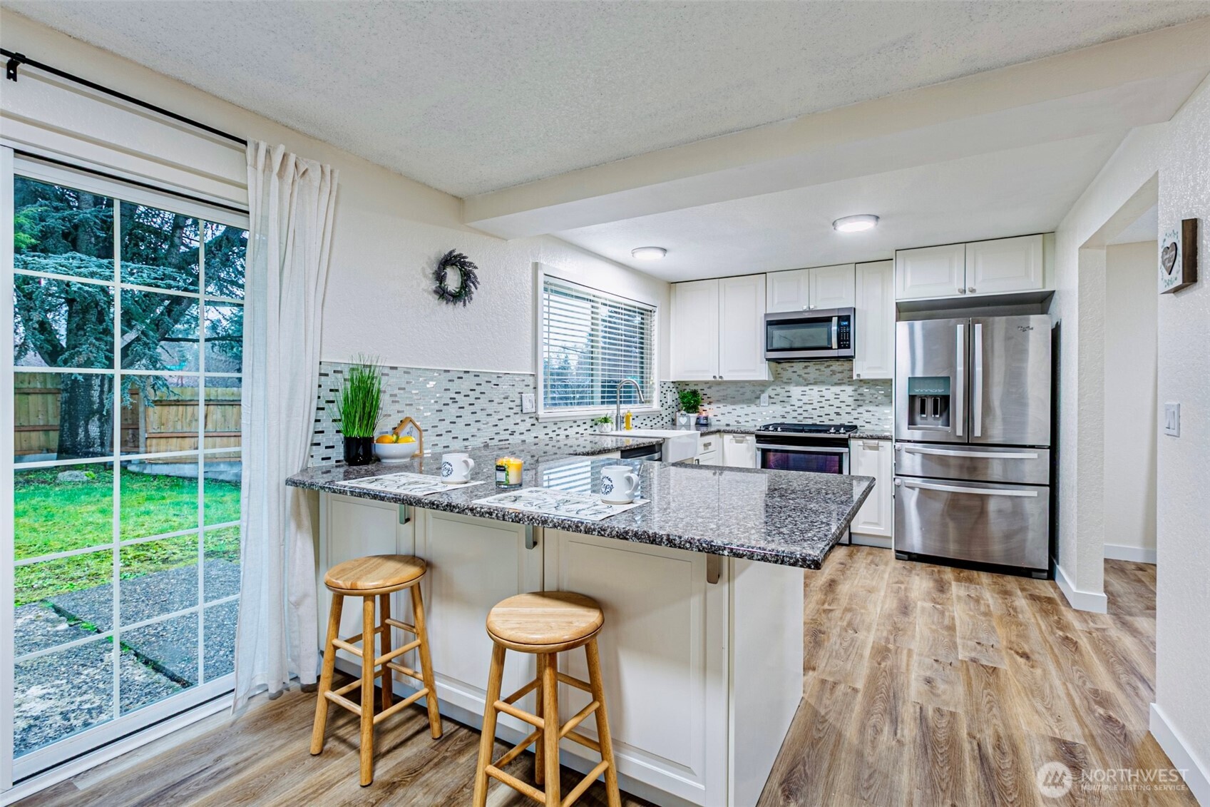 2419 Southwest 319th Place Federal Way, WA 98023 - Photo 11 of 40 a kitchen with stainless steel appliances granite countertop a stove top oven a sink dishwasher a dining table and chairs with wooden floor