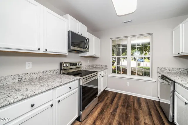 a kitchen with granite countertop a stove and a sink