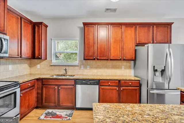 a kitchen with stainless steel appliances granite countertop a refrigerator and a sink