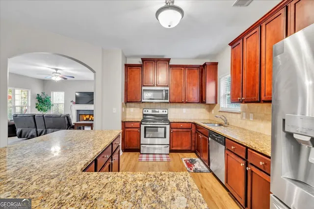 a large kitchen with stainless steel appliances granite countertop a stove a sink dishwasher a microwave oven with granite countertops and cabinets