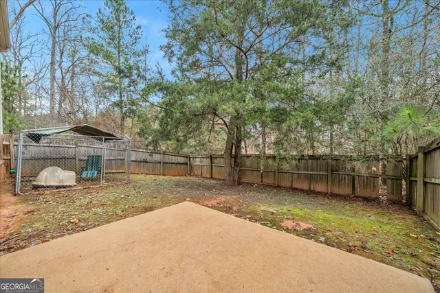 a view of a backyard with large trees and a barn