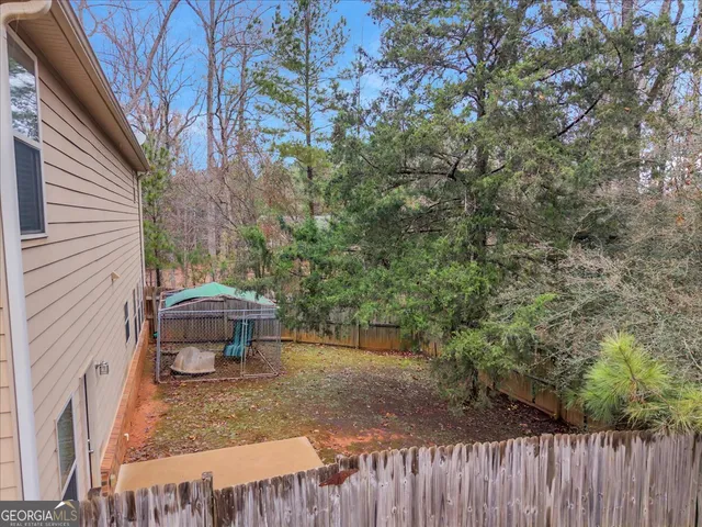 a view of a yard with wooden fence and bench
