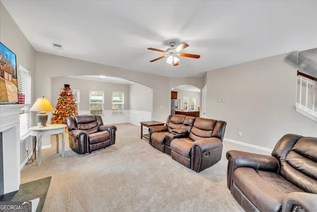 a living room with furniture ceiling fan and a window
