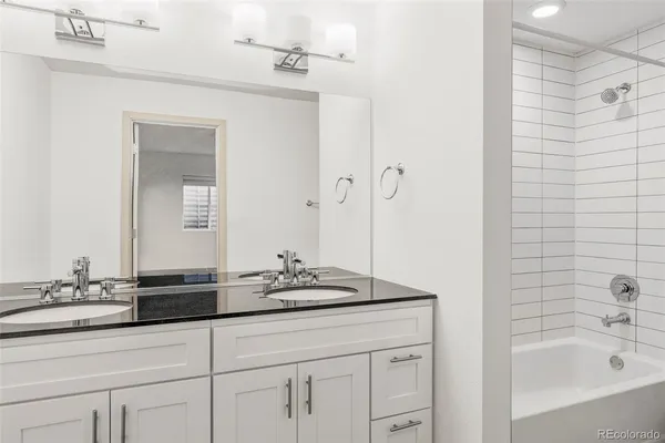 a bathroom with a granite countertop sink a mirror a shower and a bathtub