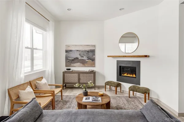 a living room with furniture two window and a fireplace