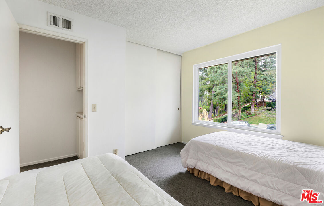 11774 Doral Avenue Porter Ranch, CA 91326 - Photo 27 of 30 a bedroom with a bed and a window