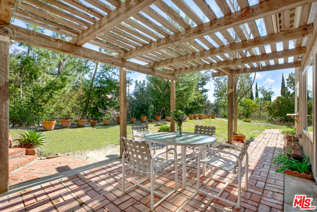 11774 Doral Avenue Porter Ranch, CA 91326 - Photo 9 of 30 a view of a patio with a table chairs and a backyard