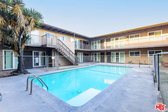 a view of an apartment with a swimming pool and sitting area