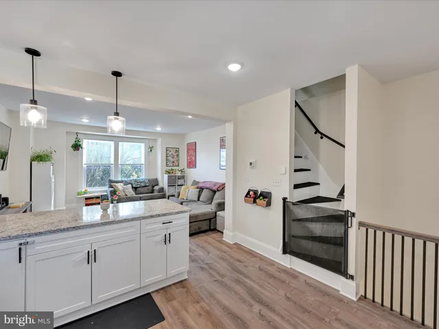 a kitchen with stainless steel appliances kitchen island granite countertop a sink cabinets and wooden floor