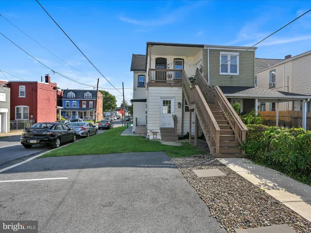 a view of a house with a yard and large parking space