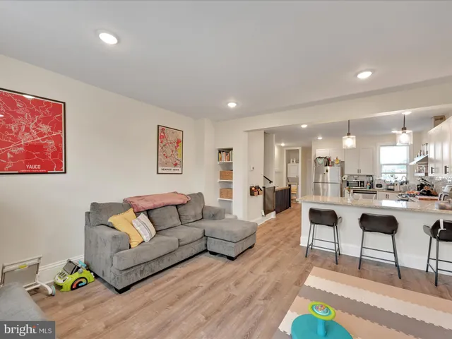 a living room with furniture and a view of kitchen